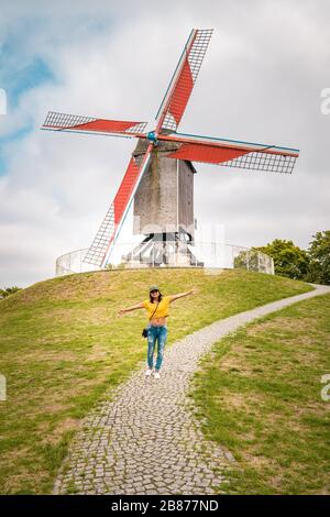 Brugge Belgium, casa colorata nella città vecchia di Brugge , giovane donna libera in città dal vecchio mulino a vento, Bruges, Belgio. Vento di Sint Janshuismolen Foto Stock