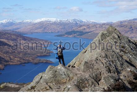 Trossachs, Scozia, Regno Unito. 20 marzo 2020. Ammirando la vista dalla cima di ben A'an guardando verso il basso Loch Katrine e le montagne innevate in una giornata di sole limpida. Credit: Craig Brown/Alamy Live News Foto Stock