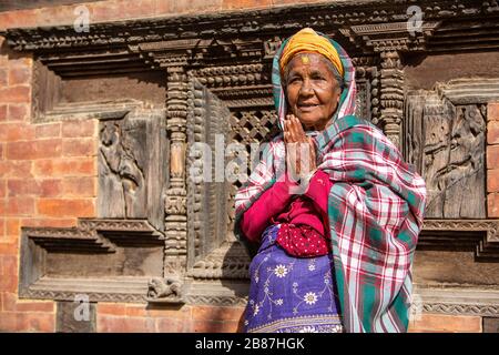 Donna che prega al Palazzo delle Finestre del 55 in Bhaktapur Durbar Square, Nepal Foto Stock