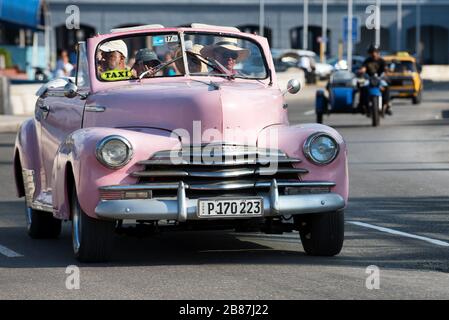 Auto americana d'epoca rosa in corsa a Malecon, una delle strade più famose dell'Avana. Vecchia Chevrolet. Foto Stock