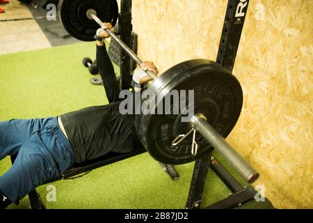 Bodybuilder con barbells pesanti in palestra Foto Stock