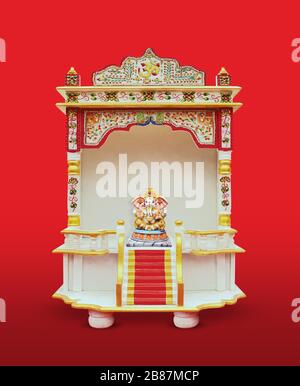 Pavimento in marmo bianco Tempio per la stanza di Puja con Ganesh Idol su sfondo rosso - isolato Foto Stock