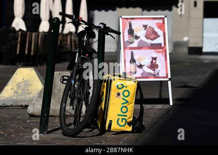 Torino, Italia. 18 Marzo 2020. TORINO, ITALIA - 18 marzo 2020: Uno zaino Glovo è collocato a terra accanto alla bicicletta. Il governo italiano ha imposto restrizioni senza precedenti per fermare la diffusione dell'epidemia di coronavirus COVID-19, tra le altre misure i movimenti delle persone sono autorizzati solo per il lavoro, per l'acquisto di beni essenziali e per motivi di salute. I ristoranti sono chiusi ai clienti, sono consentite solo le consegne a domicilio. (Foto di Nicolò campo/Sipa USA) Credit: Sipa USA/Alamy Live News Foto Stock