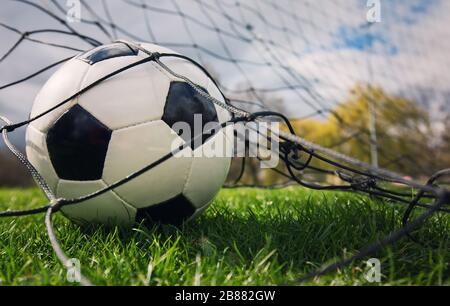 Primo piano di una palla di calcio entra nel cancello e colpisce la rete, concetto di obiettivo. Campionato di calcio, tornei primaverili all'aperto. Sport sano Foto Stock