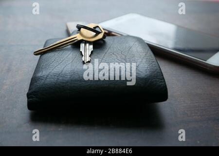 Primo piano della chiave dell'auto, del portafoglio e dello smartphone sul tavolo Foto Stock