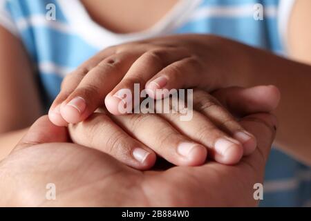 mano del padre che tiene la mano del bambino, primo piano Foto Stock