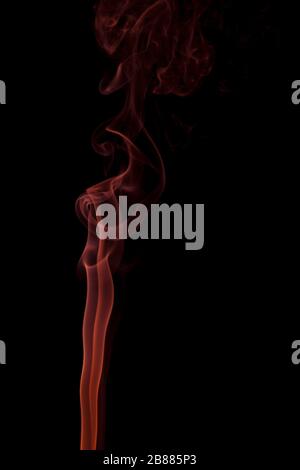 Abstract fumo arancione vorticoso su uno sfondo nero. Foto Stock