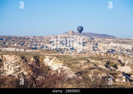 Vista panoramica della mongolfiera di prima mattina in volo, volando sopra il arido, eroso paesaggio di fiaba di Gorome, Cappadocia, Turchia Foto Stock