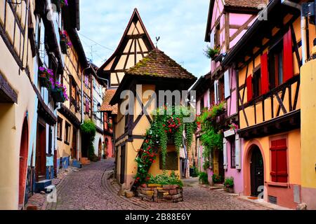Case colorate in legno della città alsaziana di Eguisheim, Francia Foto Stock
