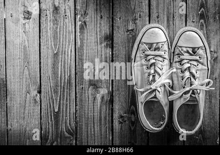 Sneakers bianche in tela da donna su pavimenti in legno duro Foto Stock