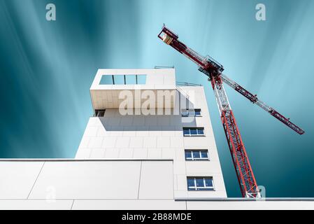 Madrid, Spagna - 31 agosto 2019: Moderno edificio residenziale in costruzione con gru contro cielo blu. Nuova area di sviluppo Valdebebas. Esp. Lunga Foto Stock