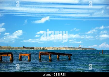 Sole che sorge sull'orizzonte e sul molo, spiaggia illuminata dalla luce del sole, Mar Nero Foto Stock