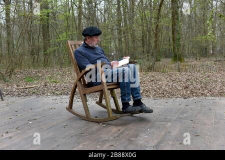 Uomo in Francia rurale seduto in sedia dondolo Foto Stock