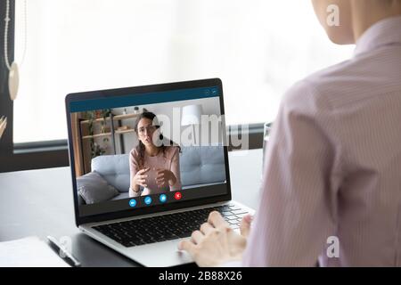 Donna d'affari che ha trattative a distanza utilizzando l'applicazione di videoconferenza su pc Foto Stock