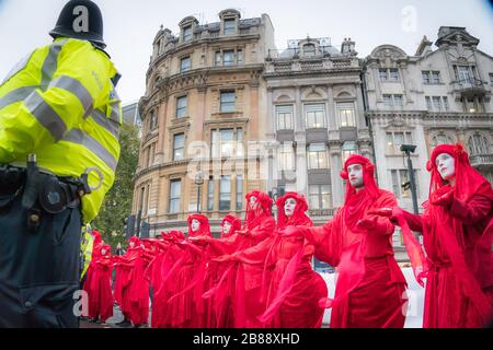 Whitehall, Londra, Regno Unito. - 7 Ottobre 2019 - estinzione della ribellione ptotests - 'Brigate Rosse' arte gruppo durante una street performance su Trafalgar Square Foto Stock