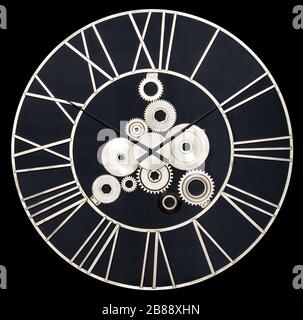 Orologio da parete industriale rotondo in metallo bianco e ingranaggi reali isolati su uno sfondo nero. Foto Stock