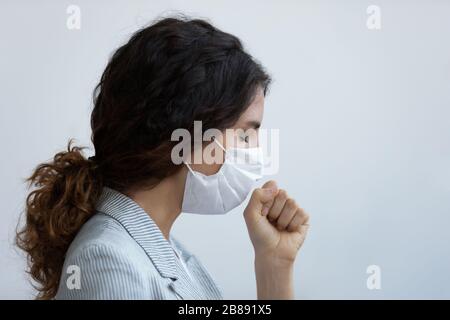 Donna in maschera medica protettiva tosse con il concetto di sintomi di coronavirus Foto Stock