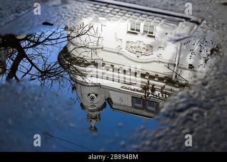 Riflessioni in pozzanghere o lago di edifici, barca o alberi e lampade da strada. Foto Stock