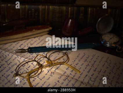 Un libro aperto o vecchie foto con un paio di occhiali Foto Stock