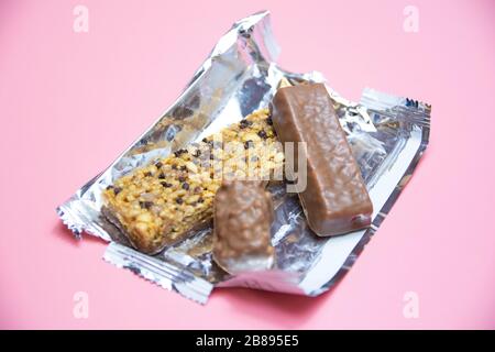 cioccolato proteine bar cibo sano su uno sfondo rosa. Foto Stock