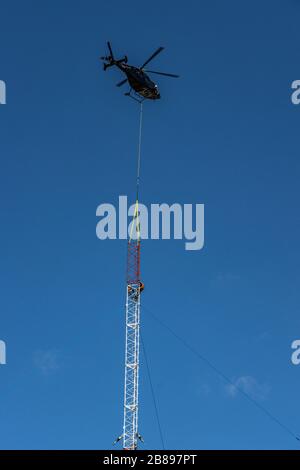 Elicottero che posiziona in posizione i nuovi componenti dell'albero della radio Foto Stock