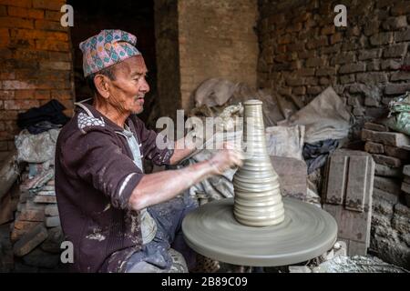 Uomo al volante del vasaio in Bhaktapur, Nepal Foto Stock