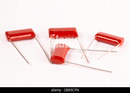 I condensatori rossi da primo piano si trovano su un tavolo bianco durante la produzione di apparecchiature per ufficio e potenti computer per l'estrazione mineraria e i videogiochi. Luogo per l'annuncio Foto Stock