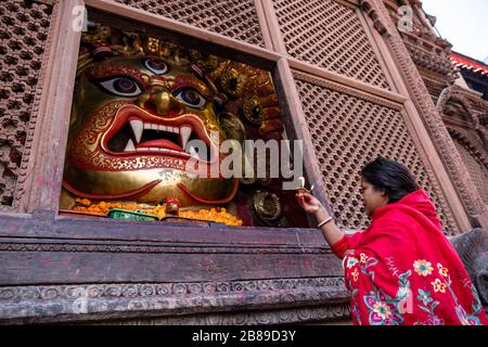 Donna indù che fa l'offerta rituale di Blairab al tempiale di Jagannath a Kathmandu, Nepal Foto Stock