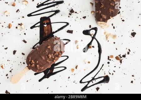 gelato al cioccolato su barre bianche con gocce di cioccolato e noci Foto Stock