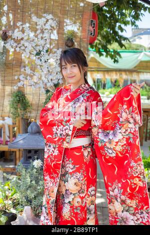 La ragazza indossa un kimono rosso tradizionale, che è l'abito nazionale del  Giappone Foto stock - Alamy