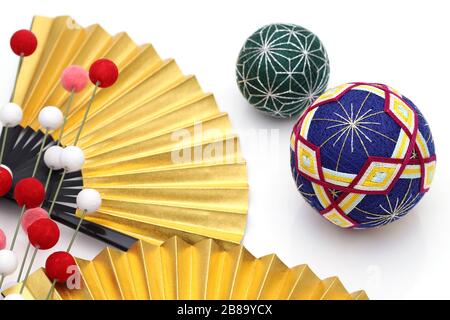 Tradizionale sfera di temari colorata giapponese con ventola pieghevole dorata su sfondo bianco Foto Stock