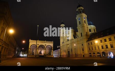 Monaco, Germania. 20 Marzo 2020. La Odeonsplatz con la Theatinerkirche illuminata è deserta intorno a 22.20. Per contenere il coronavirus, a partire dal 21 marzo si applicheranno in tutta la Baviera ampie restrizioni all'uscita. Lasciare la propria casa è poi consentito solo con buone ragioni. Credit: Felix Hörhager/dpa/Alamy Live News Foto Stock