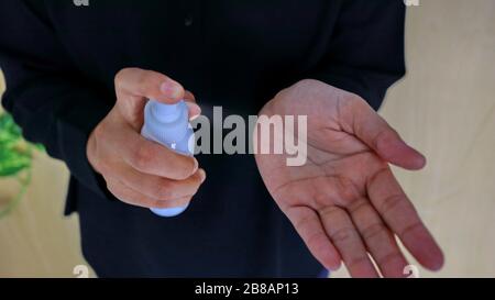 Immagine non messa a fuoco e sfocata del liquido disinfettante spray nelle mani, per uccidere il virus Foto Stock