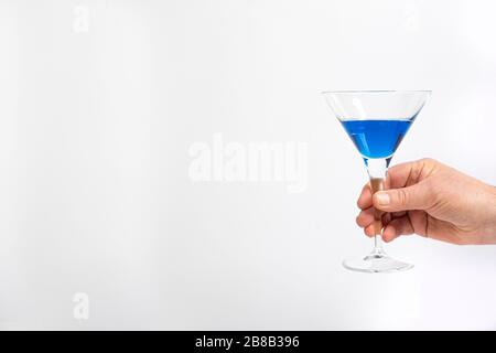 un cocktail blu in mano Foto Stock