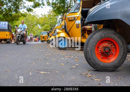 Pondicherry, India - 17 marzo 2018: Primo piano su ruote di rickshaw a motore con alcune persone irriconoscibili sullo sfondo Foto Stock