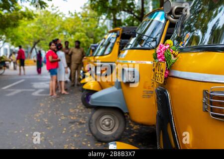 Pondicherry, India - 17 marzo 2018: Primo piano sui fronti di rickshaw motore giallo con alcune persone irriconoscibili sullo sfondo Foto Stock