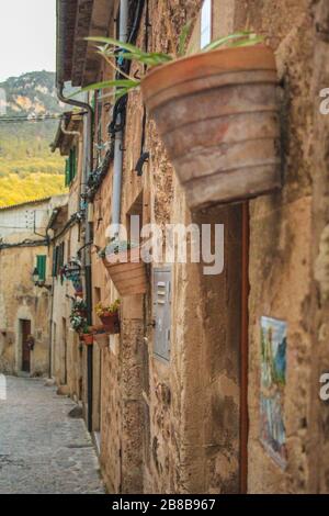 Strada vuota con vasi di fiori sul muro a Valldemossa, Maiorca, Spagna Foto Stock