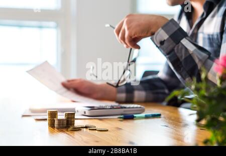 Problemi finanziari, recessione, fallimento o concetto di preclusione. Triste uomo infelice che legge la lettera, la fattura, la carta di dichiarazione della banca o il documento fiscale. Foto Stock