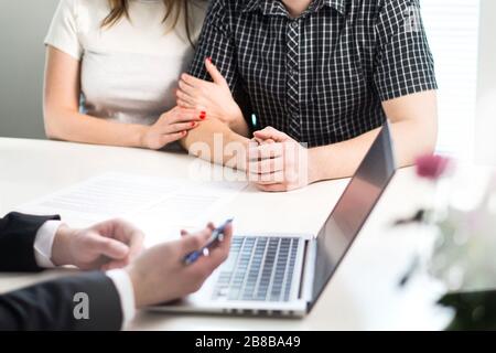 Coppia che ha un incontro con il banchiere in banca o venditore in ufficio. Consulenza finanziaria e orientamento. Persone che chiedono aiuto professionale. Foto Stock