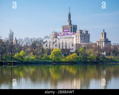 Bucarest/Romania - 03.19.2020: La Casa della libera Stampa a Bucarest visto dal Parco Herestrau o dal Parco Re Mihai I. Alberi che riflettono nell'acqua. Foto Stock