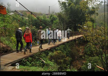 Turisti foreignt non identificati camminare a piccolo ponte sospeso a Sapa, North Veitnam. Foto Stock