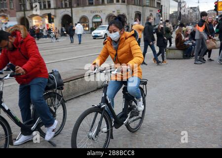 AMSTERDAM, PAESI BASSI - 11 MARZO 2020: Le persone indossano maschere facciali protettive come misura preventiva contro la diffusione del coronavirus. Foto Stock