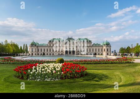 Vienna, Austria - 17 aprile 2019: Il Palazzo Belvedere superiore - complesso palazzo principale Belvedere a Vienna, Austria. Aiuole con tulipani nel foregrou Foto Stock