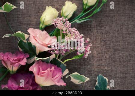 Bouquet bellissimo fiore di Eustoma (Lisianthus, tulipano genziano, eustomas) su sfondo tessuto tela di imballaggio. Stile vintage. Foto Stock