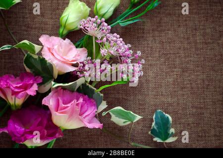 Bouquet bellissimo fiore di Eustoma (Lisianthus, tulipano genziano, eustomas) su sfondo tessuto tela di imballaggio. Foto Stock