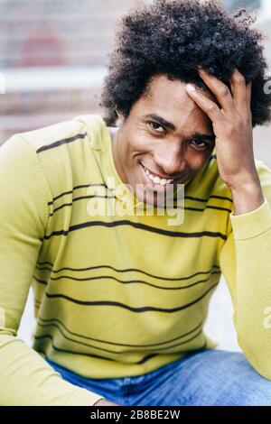 Turista cubano nero con i capelli afro seduti sul pavimento Foto Stock