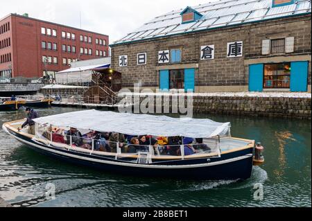 Visitatori in barca sul canale Otaru in inverno Foto Stock