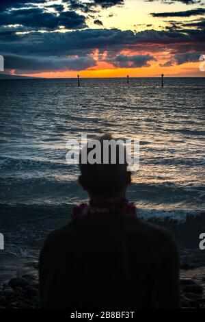 L'uomo gode di un tramonto spettacolare nelle Hawaii USA Foto Stock