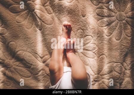 Piedi del bambino nelle mani di madre. Piccolo Neonato con i piedi sul sagomato femmina closeup mani. La mamma e il suo bambino. Happy Family concept. Bella immagine concettuale della maternità Foto Stock