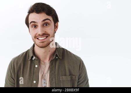 Ritratto ravvicinato di un uomo bearded felice con sorriso beaming, guardando macchina fotografica entusiasta, sollevare sopracciglia gioioso, ascoltando la storia dell'amico Foto Stock